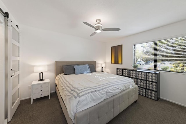 carpeted bedroom featuring ceiling fan and a barn door