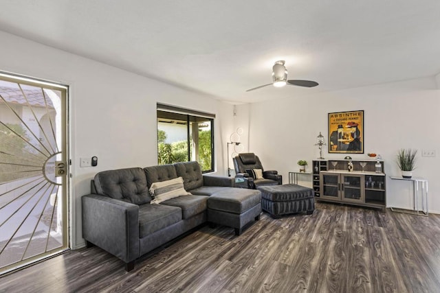 living room with dark wood-type flooring and ceiling fan