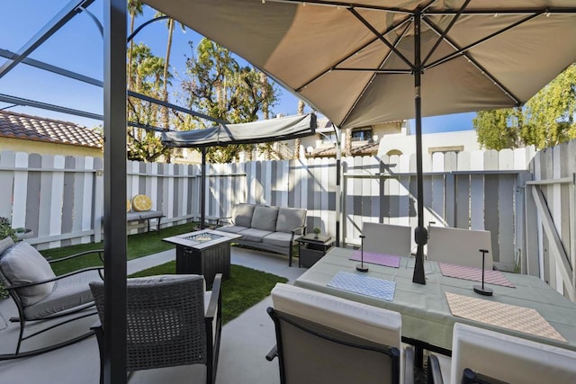 view of patio with an outdoor living space with a fire pit