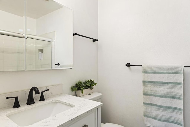 bathroom with an enclosed shower, vanity, and toilet