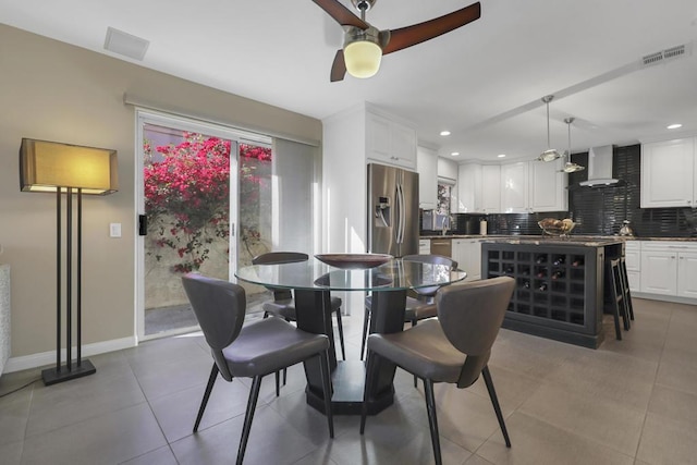 dining area with ceiling fan, tile patterned flooring, and sink