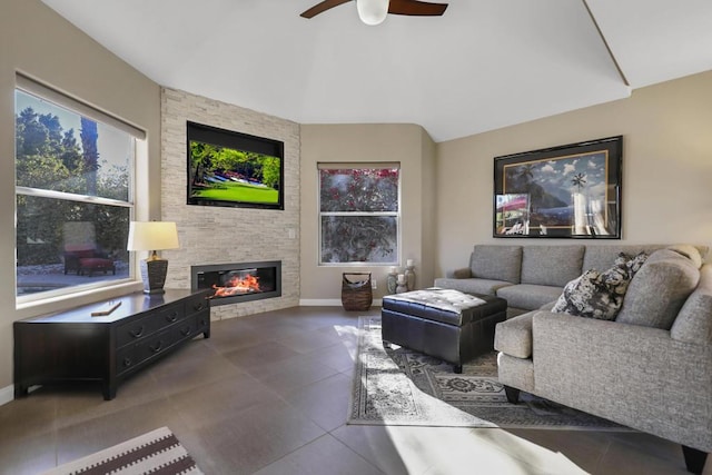 tiled living room with a fireplace and ceiling fan