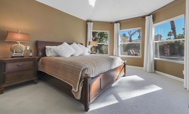 bedroom featuring light carpet and multiple windows