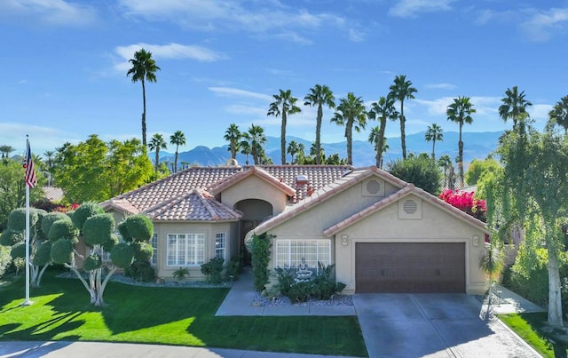 view of front of home featuring a front yard, a garage, and a mountain view