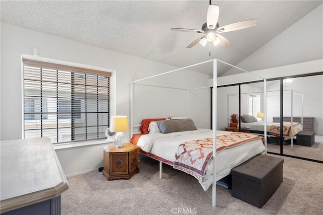 carpeted bedroom with ceiling fan, vaulted ceiling, multiple windows, and a textured ceiling