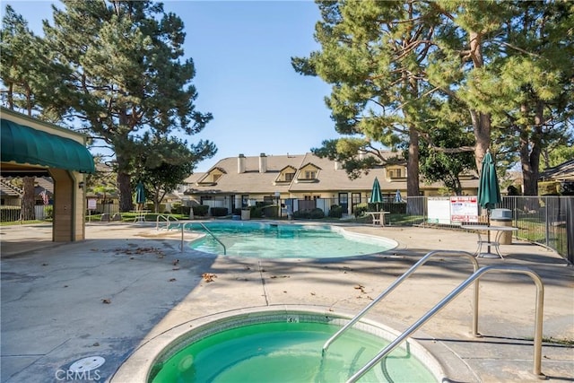 view of swimming pool with a patio area and a hot tub