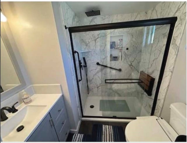 bathroom with vanity, a shower with shower door, and toilet