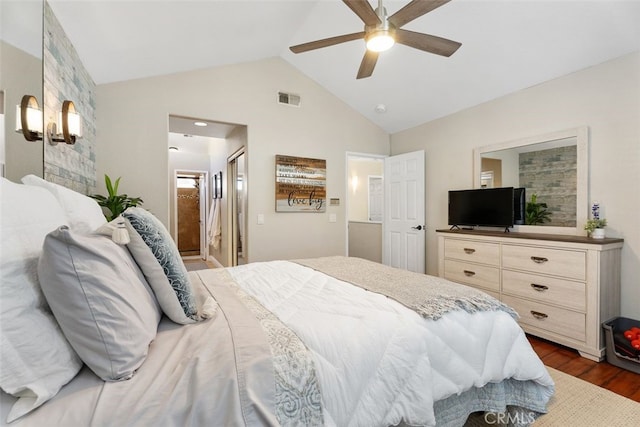 bedroom featuring ceiling fan, dark wood-type flooring, ensuite bathroom, and lofted ceiling