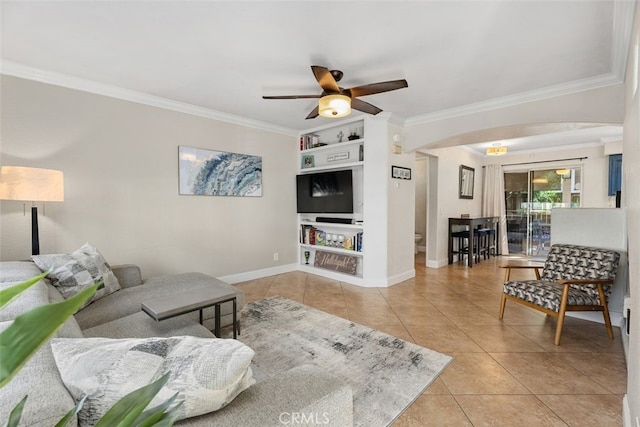 tiled living room with ceiling fan, crown molding, and built in features