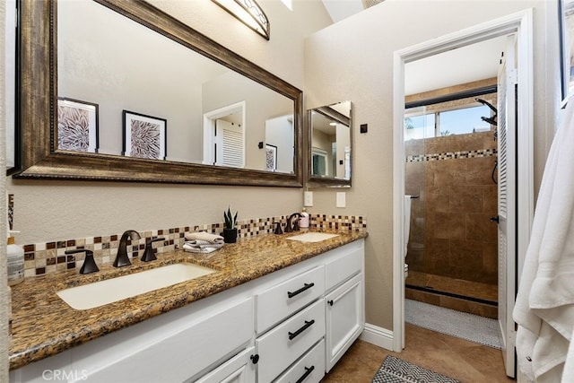 bathroom with vanity, tile patterned flooring, tiled shower, and decorative backsplash