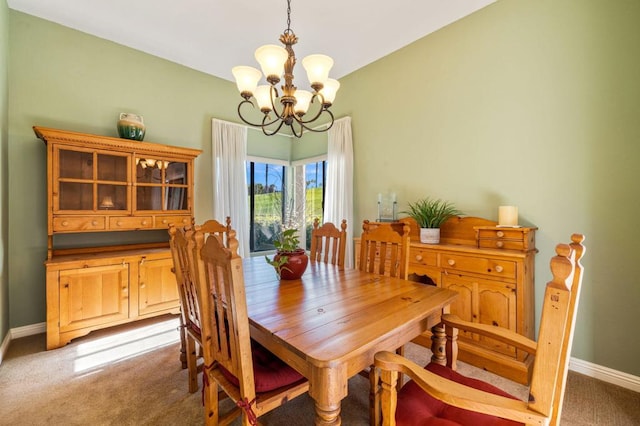 carpeted dining area with an inviting chandelier