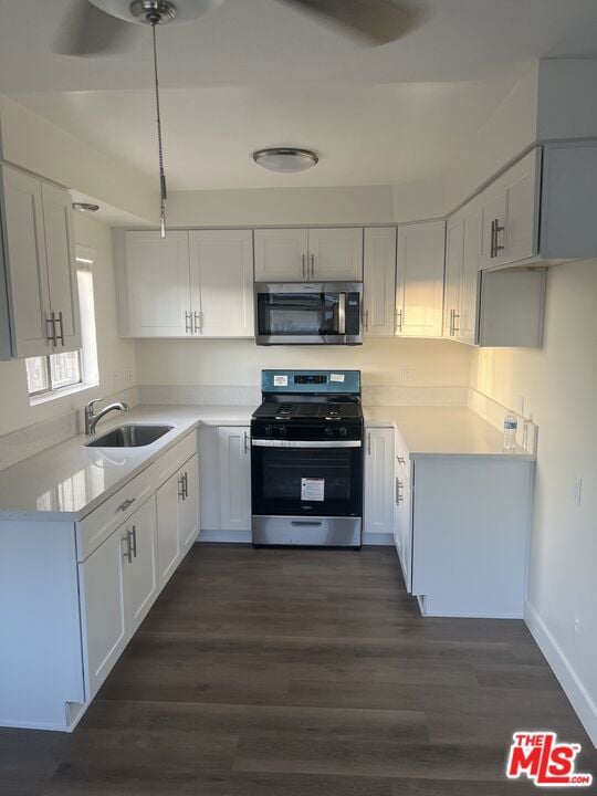 kitchen featuring sink, dark hardwood / wood-style flooring, white cabinets, and appliances with stainless steel finishes