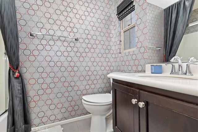 full bathroom with vanity, tile patterned flooring, toilet, and  shower combination