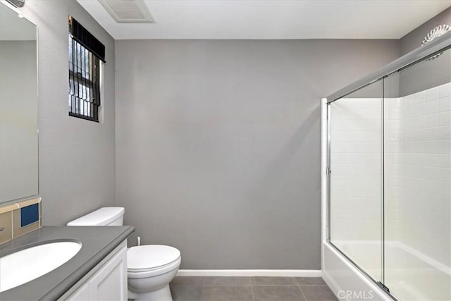 full bathroom with toilet, tile patterned flooring, enclosed tub / shower combo, and vanity