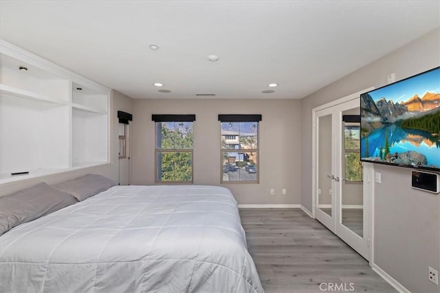 bedroom with french doors and hardwood / wood-style floors