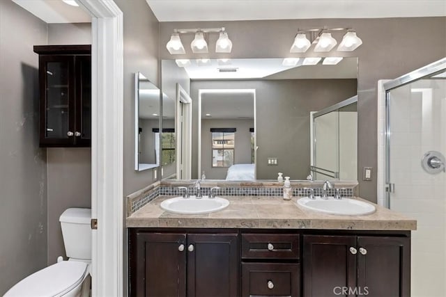 bathroom featuring toilet, an enclosed shower, and vanity