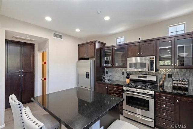 kitchen featuring plenty of natural light, stainless steel appliances, a center island, and decorative backsplash