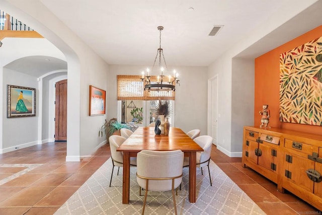 tiled dining space featuring an inviting chandelier