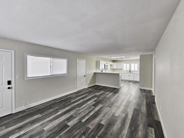 unfurnished living room with sink and dark hardwood / wood-style floors