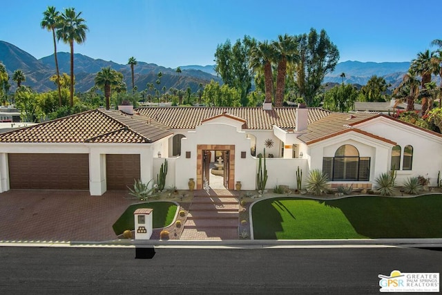 mediterranean / spanish home featuring a garage and a mountain view