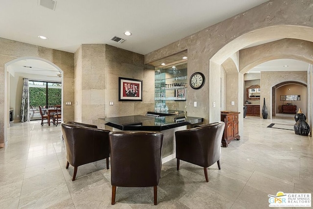 bar with tile walls and ceiling fan