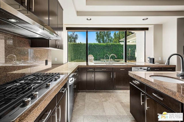 kitchen with stainless steel gas stovetop, backsplash, dark brown cabinets, and sink