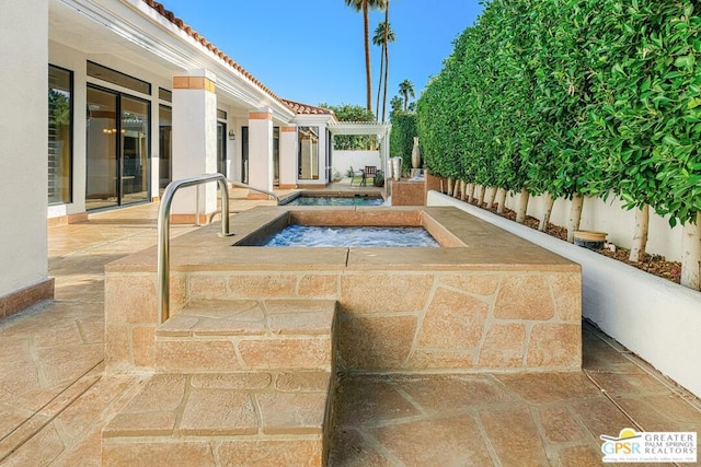 view of pool featuring an in ground hot tub and a patio