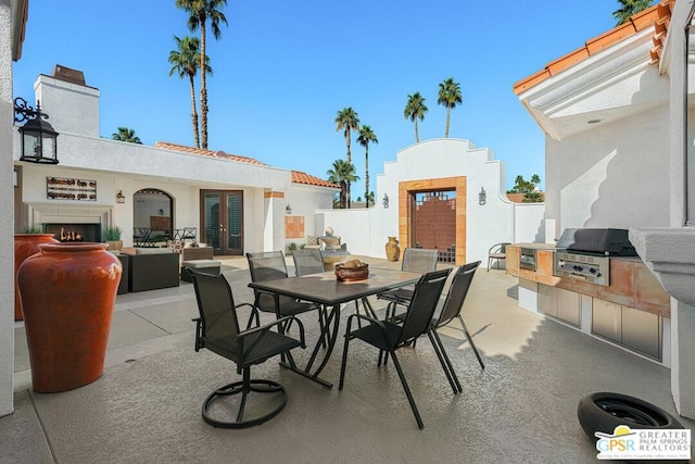 view of patio / terrace featuring a grill, area for grilling, and an outdoor fireplace