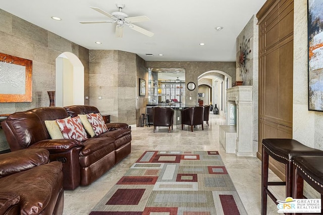 living room featuring tile walls and ceiling fan