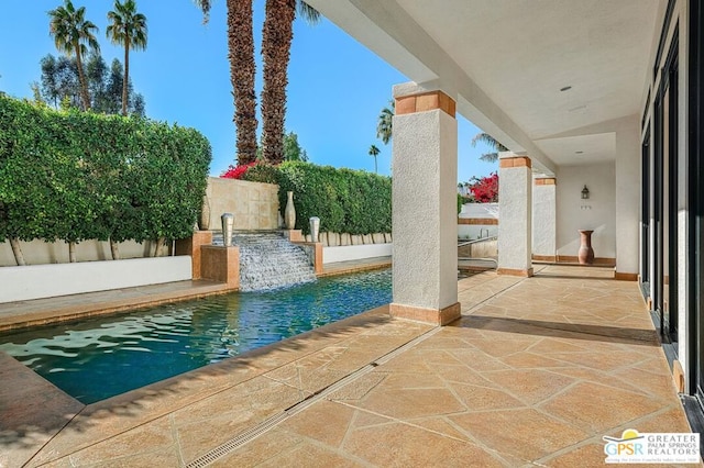 view of pool featuring pool water feature and a patio area