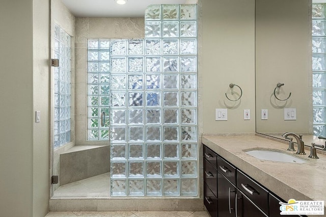 bathroom featuring a shower with door, tile patterned floors, and vanity