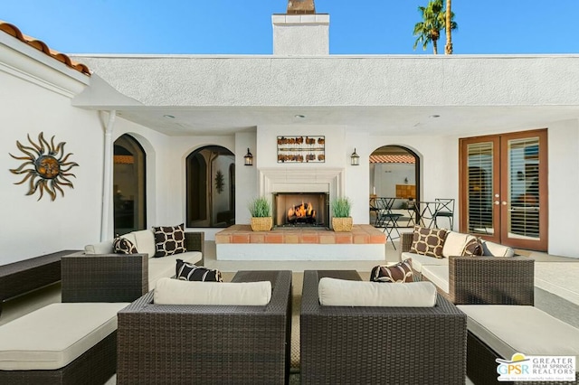 view of patio / terrace with french doors and an outdoor living space with a fireplace