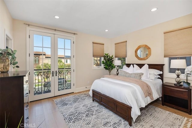 bedroom with baseboards, hardwood / wood-style flooring, access to exterior, french doors, and recessed lighting