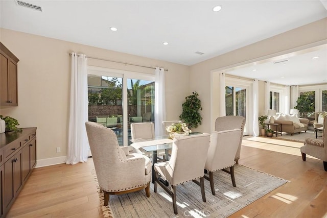 dining area with a wealth of natural light, visible vents, and light wood-style flooring