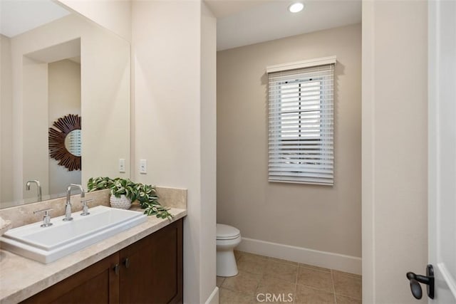 bathroom with toilet, vanity, and tile patterned floors