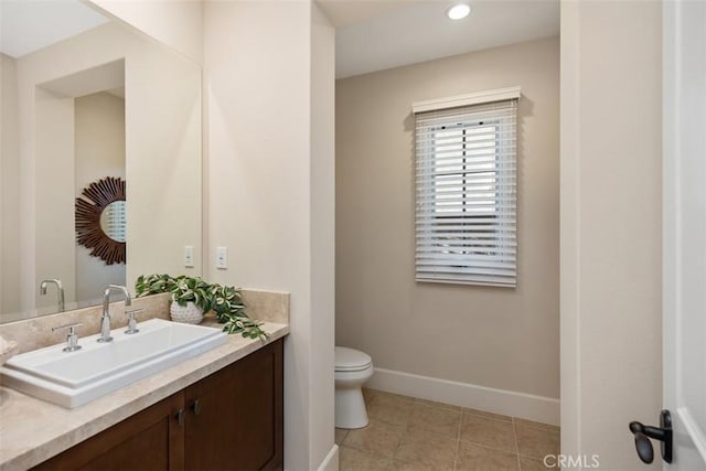 bathroom featuring toilet, recessed lighting, vanity, baseboards, and tile patterned floors