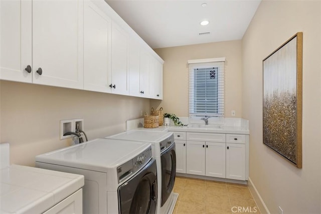 washroom featuring light tile patterned flooring, a sink, baseboards, independent washer and dryer, and cabinet space