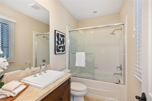 full bathroom with toilet, visible vents, combined bath / shower with glass door, and vanity