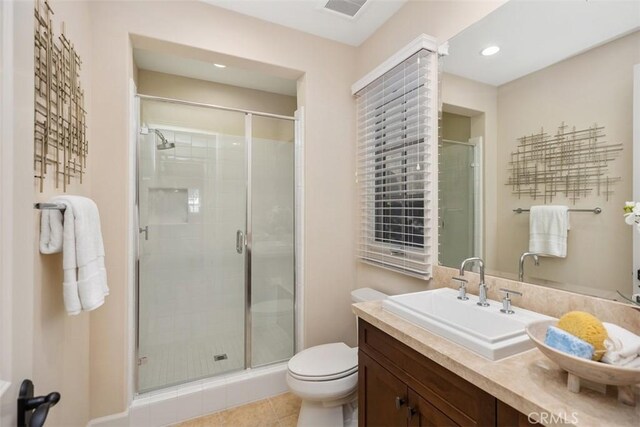 bathroom featuring walk in shower, vanity, tile patterned floors, and toilet