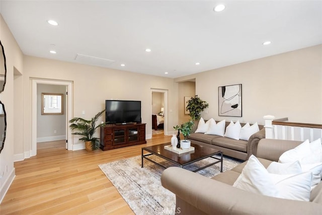 living room featuring light wood-style flooring, baseboards, and recessed lighting