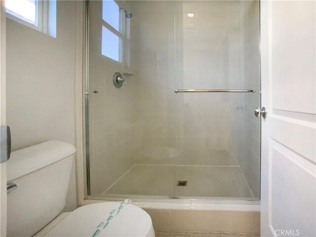 bathroom featuring an enclosed shower and toilet