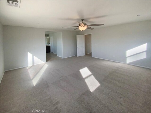 carpeted spare room featuring ceiling fan