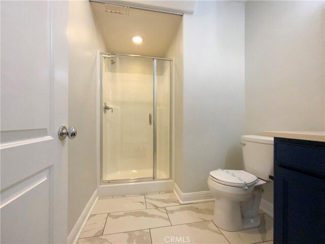 bathroom featuring a shower with door, vanity, and toilet