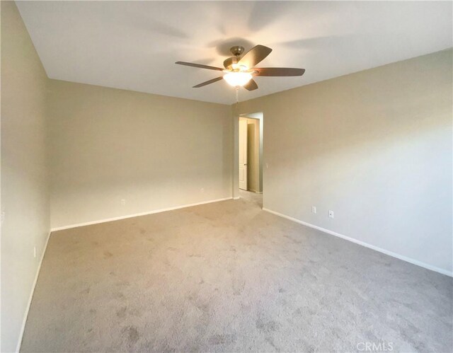 carpeted spare room with ceiling fan