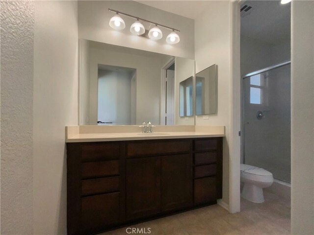 bathroom with toilet, walk in shower, and vanity