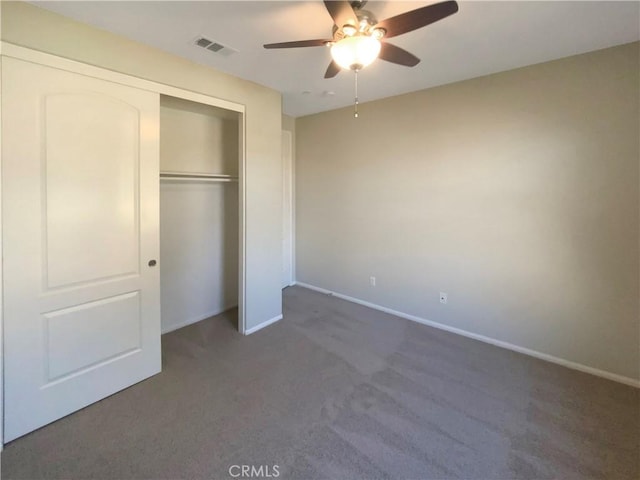 unfurnished bedroom with dark carpet, a closet, and ceiling fan