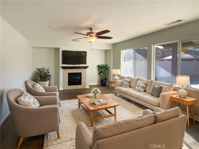 living room featuring a tile fireplace, ceiling fan, and hardwood / wood-style floors