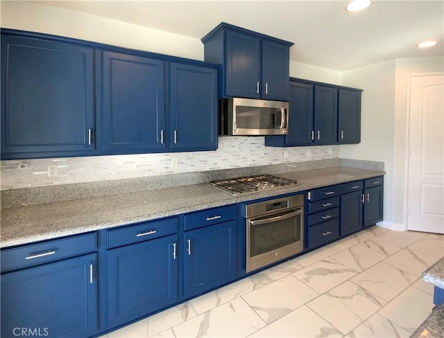 kitchen featuring blue cabinets, appliances with stainless steel finishes, and tasteful backsplash