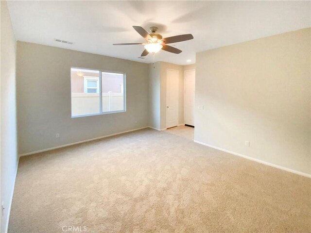 unfurnished room with ceiling fan and light colored carpet