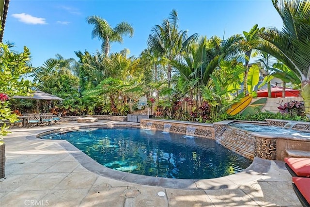 view of swimming pool featuring pool water feature, a patio area, and an in ground hot tub